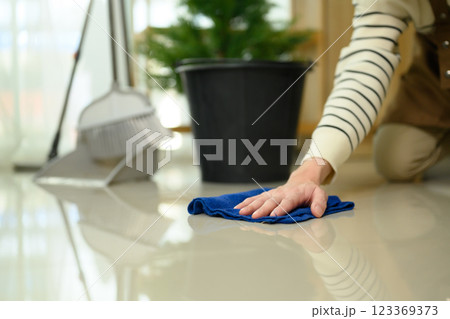 Close up of man kneeling on the floor using cloth to wipe and polish the tiles Close up of man kneeling on the floor using cloth to wipe and polish the tiles 123369373