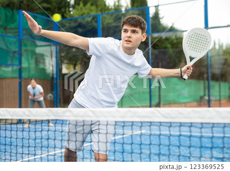 Man in sportswear playing padel tennis match during training on court Man in sportswear playing padel tennis match during training on court 123369525
