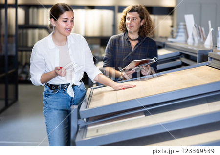 Married couple choosing ceramic tiles for new home furnishing at hardware store 123369539