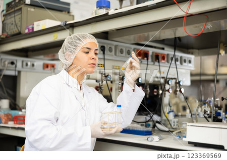 Focused female technician working in research laboratory 123369569