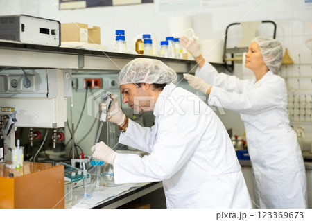 Man and woman scientists chemists conduct experiments in the laboratory Man and woman scientists chemists conduct experiments in the laboratory 123369673