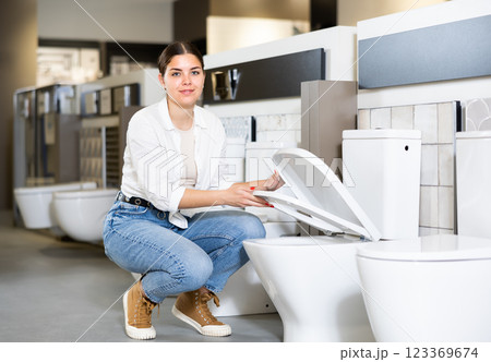 Confident female customer choosing new toilet in hardware store Confident female customer choosing new toilet in hardware store 123369674