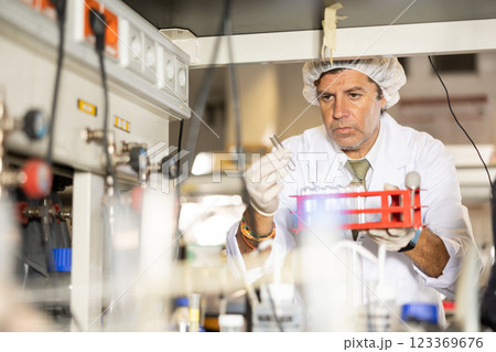 Focused man technician working in research laboratory Focused man technician working in research laboratory 123369676