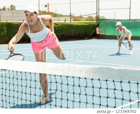 Woman playing tennis on court. Racket sport training outdoors 123369702