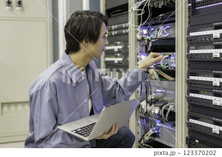 テレビ局の副調整室の機材の前で作業をする若い男性　撮影協力:スカパー東京メディアセンター 123370202