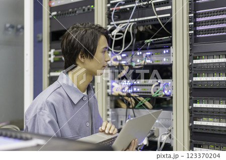 テレビ局の副調整室の機材の前で作業をする若い男性 撮影協力:スカパー東京メディアセンター テレビ局の副調整室の機材の前で作業をする若い男性 撮影協力:スカパー東京メディアセンター 123370204