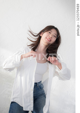 デニムを着て白い背景でダンスを踊るかわいい女性の全身 デニムを着て白い背景でダンスを踊るかわいい女性の全身 123370489