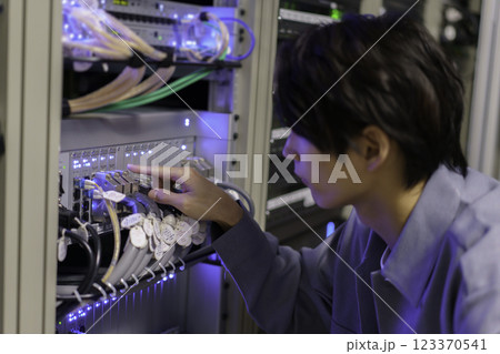オフィスの機材の前で作業をする若い男性　撮影協力:スカパー東京メディアセンター 123370541