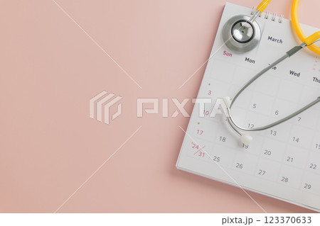 Doctor Day design with calendar and yellow stethoscope on pink. A theme promoting annual checkups Doctor Day design with calendar and yellow stethoscope on pink. A theme promoting annual checkups 123370633