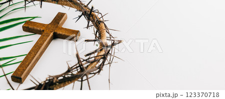 Wooden cross with crown of thorns and palm leaves on white for Palm Sunday. Wooden cross with crown of thorns and palm leaves on white for Palm Sunday. 123370718