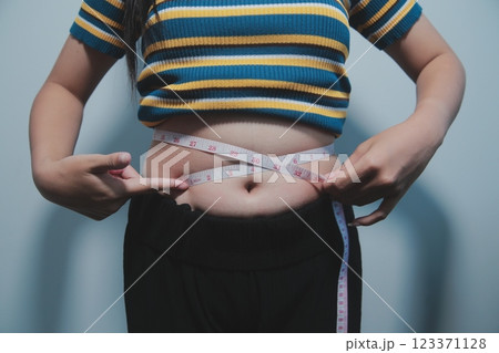 Women body fat belly. Obese woman hand holding excessive belly fat. diet lifestyle concept to reduce belly and shape up healthy stomach muscle. Women body fat belly. Obese woman hand holding excessive belly fat. diet lifestyle concept to reduce belly and shape up healthy stomach muscle. 123371128