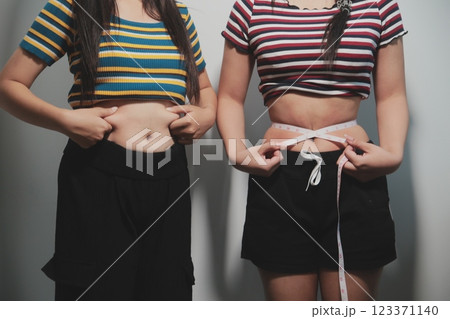 Women body fat belly. Obese woman hand holding excessive belly fat. diet lifestyle concept to reduce belly and shape up healthy stomach muscle. Women body fat belly. Obese woman hand holding excessive belly fat. diet lifestyle concept to reduce belly and shape up healthy stomach muscle. 123371140