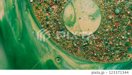 Acrylic blob. Paint mix. Shimmering metal particles gel drop floating in green water. Abstract defocused moisture bubble burst background. Acrylic blob. Paint mix. Shimmering metal particles gel drop floating in green water. Abstract defocused moisture bubble burst background. 123371344