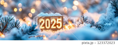 Glittering '2025' sign covered in snow with warm bokeh lights, perfect for New Year celebrations 123372023