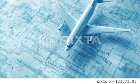 Model airplane is lying on top of a technical drawing of an aircraft, suggesting the concept of aircraft design and engineering 123372383