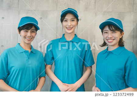 青いポロシャツと帽子着用の女性スタッフ 123372499