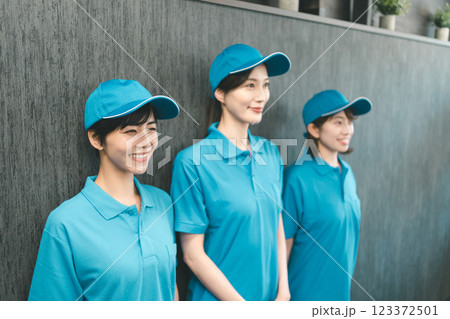 青いポロシャツと帽子着用の女性スタッフ 123372501