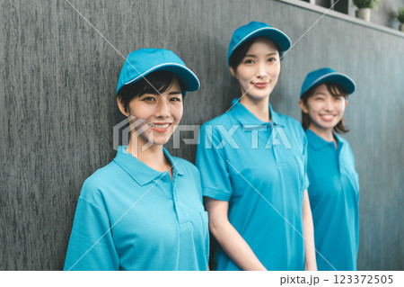 青いポロシャツと帽子着用の女性スタッフ 123372505