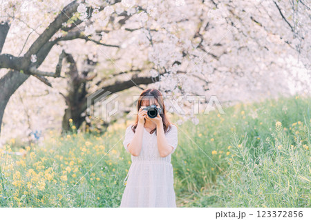 春の公園で菜の花を撮る女性 春の公園で菜の花を撮る女性 123372856