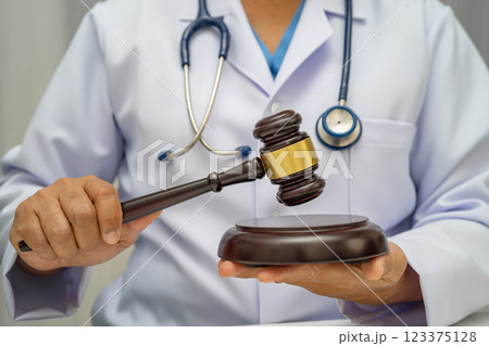 Doctor holding judge gavel, forensic medicine, medical law and crime justice. 123375128