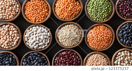 木製ボウルに盛られた色とりどりの豆とレンズ豆のディスプレイ  123375237