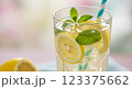 Refreshing homemade lemonade with ice cubes, lemon slices, and mint, served in a tall glass with a striped straw, bright spring aesthetic, ultra-detailed, close-up 123375662