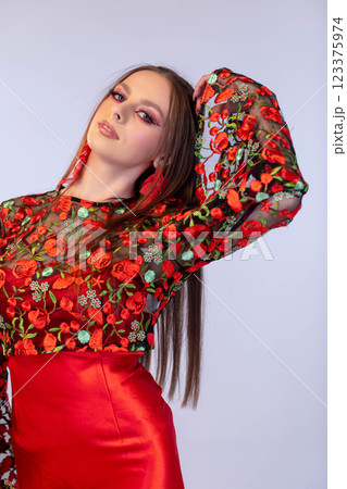 An Elegant Model in a Stunning Floral Red Ensemble Showcasing Her Long, Flowing Hair An Elegant Model in a Stunning Floral Red Ensemble Showcasing Her Long, Flowing Hair 123375974