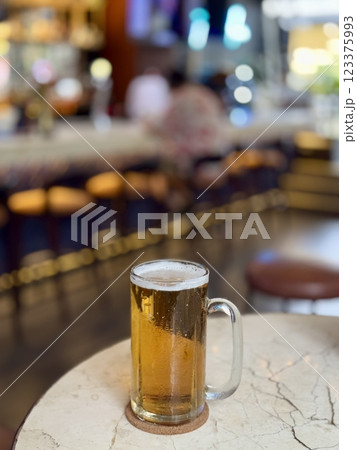 A glass of light beer is on the table 123375993