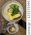 Breakfast with scrambled eggs, toast, sausage, cherry tomatoes, lettuce and avocado on a white plate 123375995