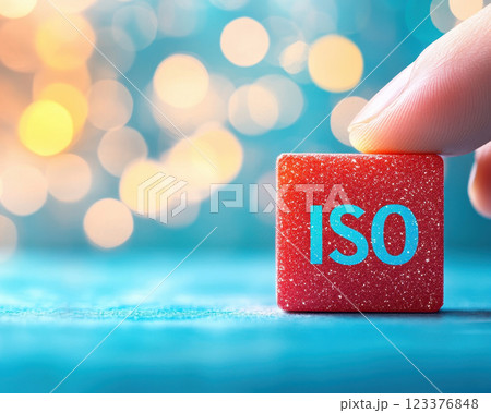 Close up of hand positioning ISO block on colorful background, emphasizing importance of ISO settings in photography. vibrant colors create captivating atmosphere 123376848