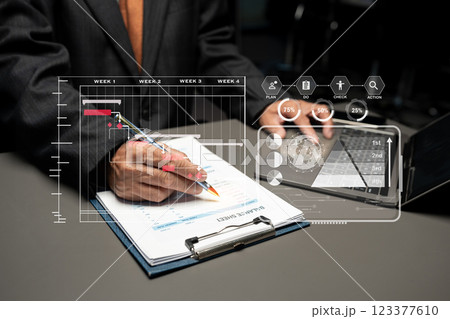 Businessman hand Project manager working and update tasks and Gantt chart scheduling virtual diagram.with smart phone, tablet and laptop in office. 123377610