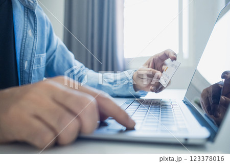 Man holding credit card while using laptop, shopping online, buying on internet. e-commerce e-banking service. 123378016