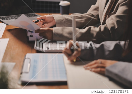 Group of confident business people point to graphs and charts to analyze market data, balance sheet, account, net profit to plan new sales strategies to increase production capacity. 123378171