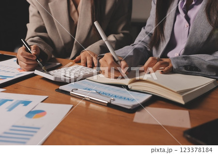 Group of confident business people point to graphs and charts to analyze market data, balance sheet, account, net profit to plan new sales strategies to increase production capacity. 123378184