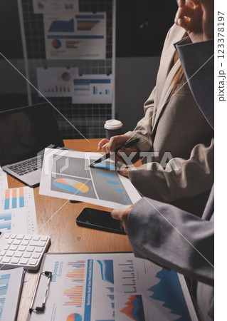 Group of confident business people point to graphs and charts to analyze market data, balance sheet, account, net profit to plan new sales strategies to increase production capacity. Group of confident business people point to graphs and charts to analyze market data, balance sheet, account, net profit to plan new sales strategies to increase production capacity. 123378197