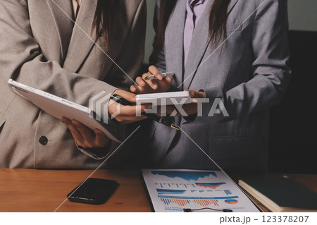 Group of confident business people point to graphs and charts to analyze market data, balance sheet, account, net profit to plan new sales strategies to increase production capacity. Group of confident business people point to graphs and charts to analyze market data, balance sheet, account, net profit to plan new sales strategies to increase production capacity. 123378207