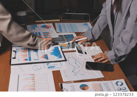 Group of confident business people point to graphs and charts to analyze market data, balance sheet, account, net profit to plan new sales strategies to increase production capacity. 123378233