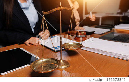 Attractive young lawyer in office Business woman and lawyers discussing contract papers with brass scale on wooden desk in office. Law, legal services, advice, Justice and real estate concept. 123378243