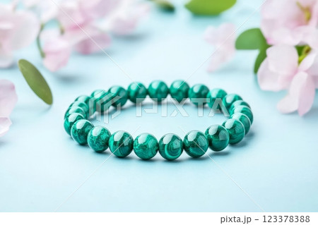 Elegant green gemstone bracelet surrounded by soft floral elements 123378388