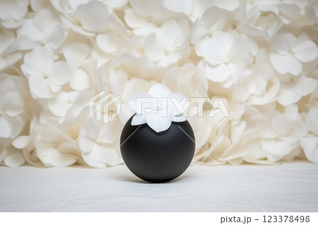 Elegant black vase adorned with white flowers in serene setting 123378498