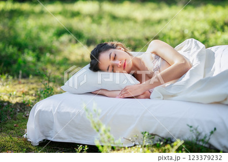 Woman sleeps on a mattress in the summer forest Woman sleeps on a mattress in the summer forest 123379232