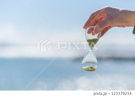 海辺で砂時計を持っている人 海辺で砂時計を持っている人 123379254