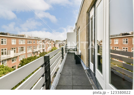 A spacious balcony overlooking an urban landscape with contemporary architecture and greenery. Ideal for relaxation and enjoying the fresh air. A spacious balcony overlooking an urban landscape with contemporary architecture and greenery. Ideal for relaxation and enjoying the fresh air. 123380022