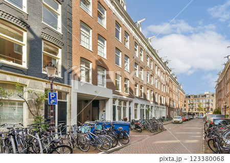 A picturesque urban street lined with bicycles and classic brick buildings under a blue sky. The inviting atmosphere showcases a vibrant city life. A picturesque urban street lined with bicycles and classic brick buildings under a blue sky. The inviting atmosphere showcases a vibrant city life. 123380068