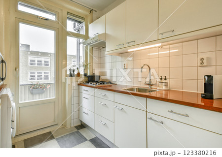 A sleek, modern kitchen featuring minimalist design, natural light flooding through large windows, and contemporary appliances. A sleek, modern kitchen featuring minimalist design, natural light flooding through large windows, and contemporary appliances. 123380216