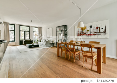 A stylish modern living room featuring a wooden dining table, elegant furnishings, and artistic wall decor, creating a cozy and inviting atmosphere. A stylish modern living room featuring a wooden dining table, elegant furnishings, and artistic wall decor, creating a cozy and inviting atmosphere. 123380276