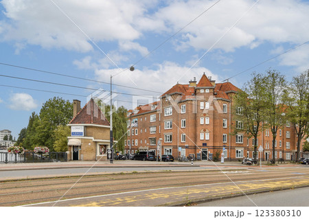 Captivating view of a charming urban landscape showcasing historic architecture, trees lining the street, and vibrant blue sky. 123380310