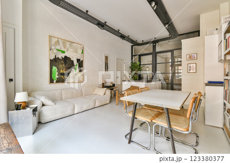 A contemporary living room featuring a cozy sofa, stylish furniture, and an elegant art piece, showcasing a blend of comfort and modern design aesthetics. 123380377