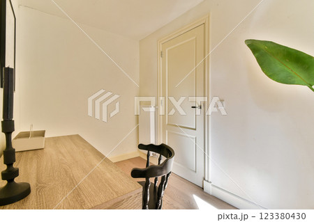 A bright, minimalist interior featuring wooden furnishings and a potted plant. The natural light creates a serene atmosphere in the room. 123380430