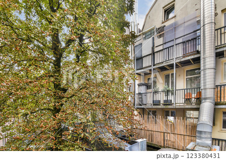 A contemporary apartment building showcasing a blend of architectural styles with balconies and greenery, highlighting urban living aesthetics. 123380431